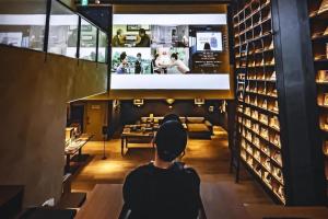a man sitting in a restaurant looking at a bar at TUNE STAY KYOTO in Kyoto