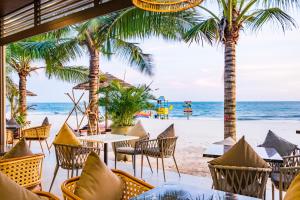 Hoang Ngoc Beach Resort في موي ني: مطعم على الشاطئ يوجد به نخل والمحيط