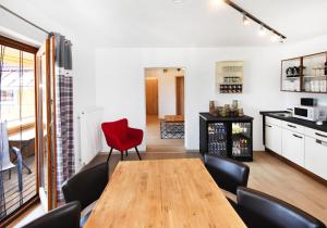 a dining room with a wooden table and a red chair at 8peaks in Pfronten