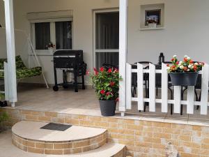 weranda z dwoma doniczkami i białym płotem w obiekcie Holiday Home Balatonszárszó w mieście Balatonszárszó