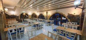 a restaurant with tables and chairs in a room at Erato Hotel in Kokkini Khanion