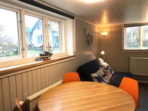 a room with a table and a chair and windows at Hagaborg Bed & Breakfast in Köpingsvik