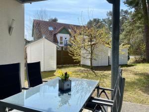 einen Tisch mit einer Blumenvase auf einer Terrasse in der Unterkunft Dünenresidenz Karlshagen - Ferienwohnung am Sanddornweg in Ostseebad Karlshagen