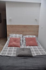 ein großes Bett mit zwei Kissen darüber in der Unterkunft Studio avec terrasse privative et piscine in Grillon