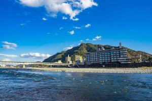 a building on the shore of a river with a bridge at Juhachiro in Gifu