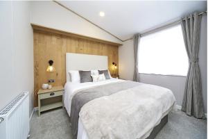 una camera da letto con un letto grande e una finestra di Luxury Lodge - Hoburne Devon Bay a Paignton