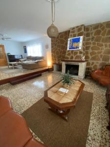 a living room with a stone fireplace and a table at Villa Mis 5 Amores con piscina in Benidorm