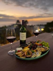 a plate of food and a bottle of wine and wine glasses at Royal Boutique Hotel in Cape Town