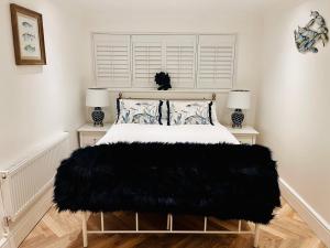 a bedroom with a bed with a black blanket on it at Coastal Cottage in North Wales With Hot Tub in Abergele