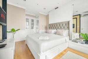 A bed or beds in a room at BLANC by Kozystay - 1BR Apartment in SCBD