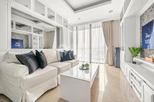 un soggiorno bianco con divano bianco e tavolo di BLANC by Kozystay - 1BR Apartment in SCBD a Giacarta