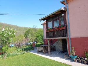 a house with a balcony with a table and flowers at Kuca Jablansko Polje in Krepoljin