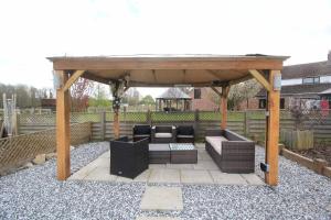 a gazebo with two couches sitting under it at Beautiful rural cottage with secure garden in Bradley