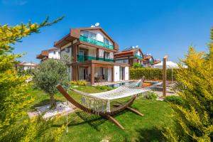a house with a hammock in front of it at 4 Beds, Luxury Holiday Villa in Hisarönü Ölüdeniz Villa Mia in Fethiye