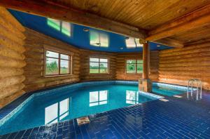 a swimming pool in a room with a wooden wall at Saules sēta 