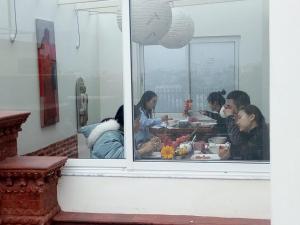un gruppo di persone sedute a tavola che mangiano cibo di TARA ART HOUSE a Patan