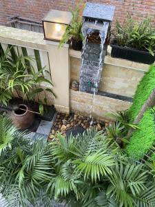 una fuente de agua en un jardín con plantas en The Quin Riverside Villa en Hoi An