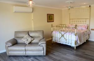 a bedroom with a bed and a chair and a bed at The stables in Wandin North
