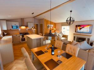Luxury Lodge - Hoburne Devon Bay في بينتون: مطبخ وغرفة معيشة مع طاولة طعام