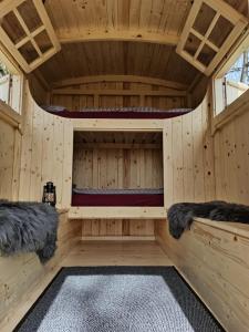 eine Holzsauna mit 2 Betten in einer Hütte in der Unterkunft Schäferwagen auf dem Biogut-Saalkow in Gustow