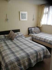 Un dormitorio con dos camas y una ventana. en Ashton Holiday Flats Seaviews, en Bridlington