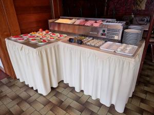 a table with a white table cloth with food on it at Pension Bergfried in Hallstatt