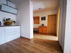 a kitchen with white walls and a wooden floor at Pension Bergfried in Hallstatt