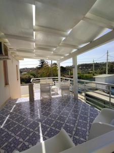a balcony with chairs and tables on a roof at Casa Vacanze Playa 54 in Castellammare del Golfo