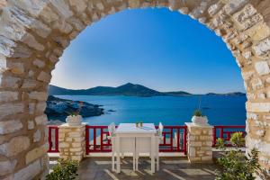 um arco com uma mesa e vista para o oceano em Katerina mare em Naousa