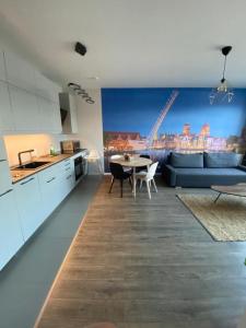 Il dispose d'une cuisine et d'un salon avec un canapé et une table. dans l'établissement Blue Raven Downtown Apartments, à Gdańsk