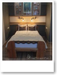 a large bed with a wooden frame in a room at Wellnesska Vyhne in Vyhne