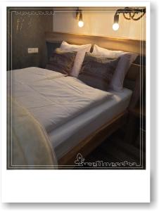 1 cama grande con sábanas y almohadas blancas en Wellnesska Vyhne, en Vyhne