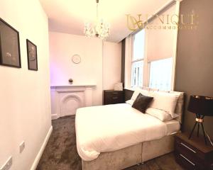 sypialnia z białym łóżkiem i kominkiem w obiekcie Unique Accommodation Liverpool - Luxury 2 Bed Apartments , Perfect for Business & Families, Book Now w Liverpoolu