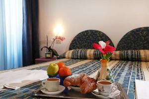 a table with a tray of food on a bed at Hotel Residence S.Angelo in Ischia