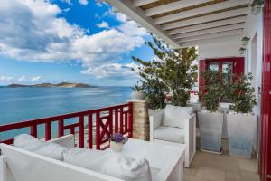 balcón con muebles blancos y vistas al océano en Katerina mare, en Naousa