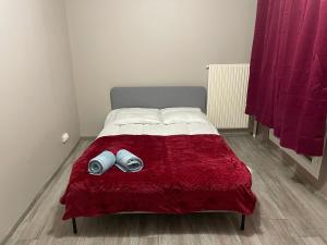 um quarto com uma cama com um cobertor vermelho em Bel appartement composé de deux chambres em Saint Etienne