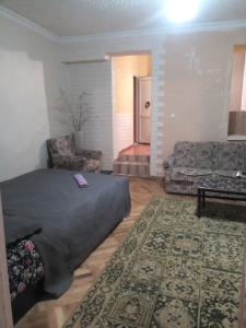 a living room with a bed and a couch at Guest House Rose in Borjomi