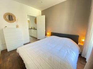 a bedroom with a white bed and a mirror at Le Cosy in Melun