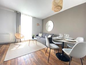 a living room with a couch and a table and chairs at Le Cosy in Melun