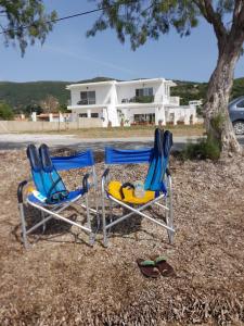 two chairs and flip flops sitting in front of a house at MAREMARI VILLA in Ayía Marína