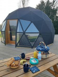 una mesa de picnic con comida encima de una tienda en Dôme La vue étoilée en Poinson-lès-Fays