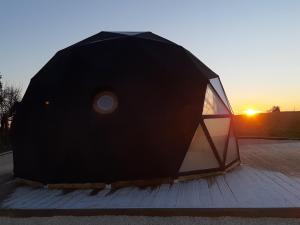 ein schwarzes Zelt mit Sonnenuntergang im Hintergrund in der Unterkunft Dôme La vue étoilée in Poinson-lès-Fays