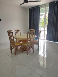 a dining room with a wooden table and chairs at Juliana Homestay in Jitra