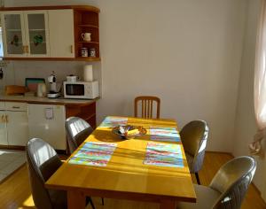 mesa de comedor con sillas y cocina en Lovely 2-bedroom appartment with free parking, en Dobrova