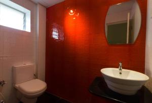 a bathroom with a toilet and a sink and a mirror at Sandhya Residency in Bangalore