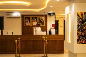 a woman standing at the counter of a restaurant at Quiet Room 9 By Quiet Rooms in Riyadh
