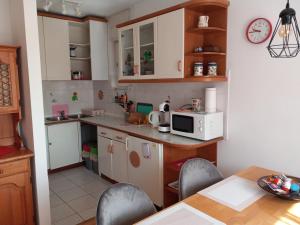 una cocina con armarios blancos y una mesa con sillas. en Lovely 2-bedroom appartment with free parking, en Dobrova