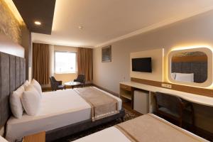 ein Hotelzimmer mit einem Bett und einem TV in der Unterkunft Gurtas Hotel in Antalya