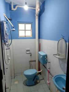 uma casa de banho com um WC azul e um lavatório. em HOLIDAY APARTMENT AT PD PERDANA CONDO RESORT em Porto Dickson