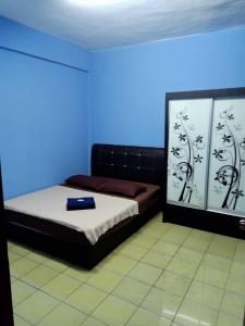 um quarto com uma cama com fundo azul em HOLIDAY APARTMENT AT PD PERDANA CONDO RESORT em Porto Dickson